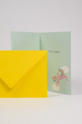 biglietto auguri azzurro con unicorno rosa interno e busta gialla