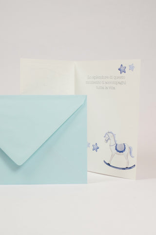 biglietto di auguri di battesimo con cavalluccio a dondolo per bimbo interno con frase di auguri e busta azzurra